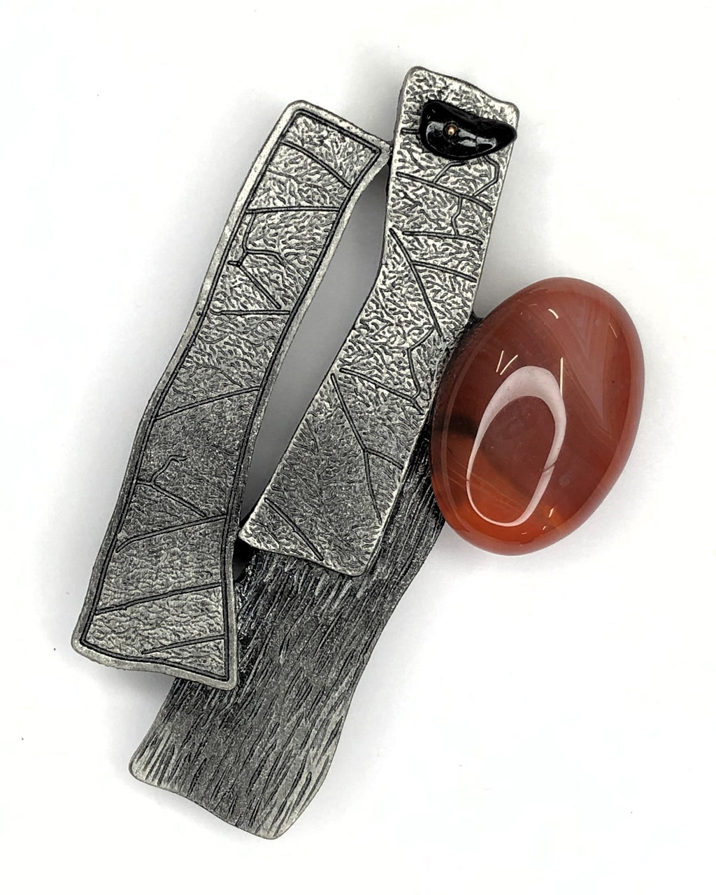 Abstract brushed metal shapes with rust coloured stone brooch at erika