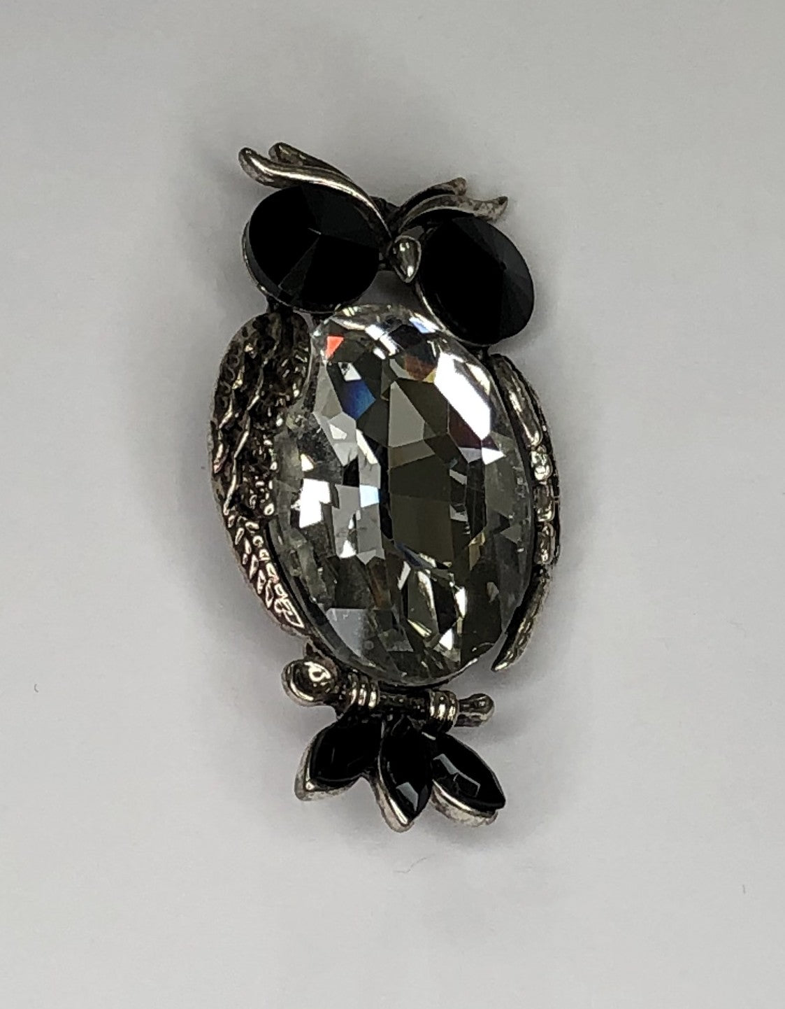 Silver owl with large faceted clear body and black eyes and tail feathers brooch at erika
