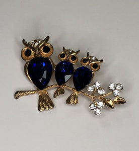 Three blue owls perched on branch brooch at erika