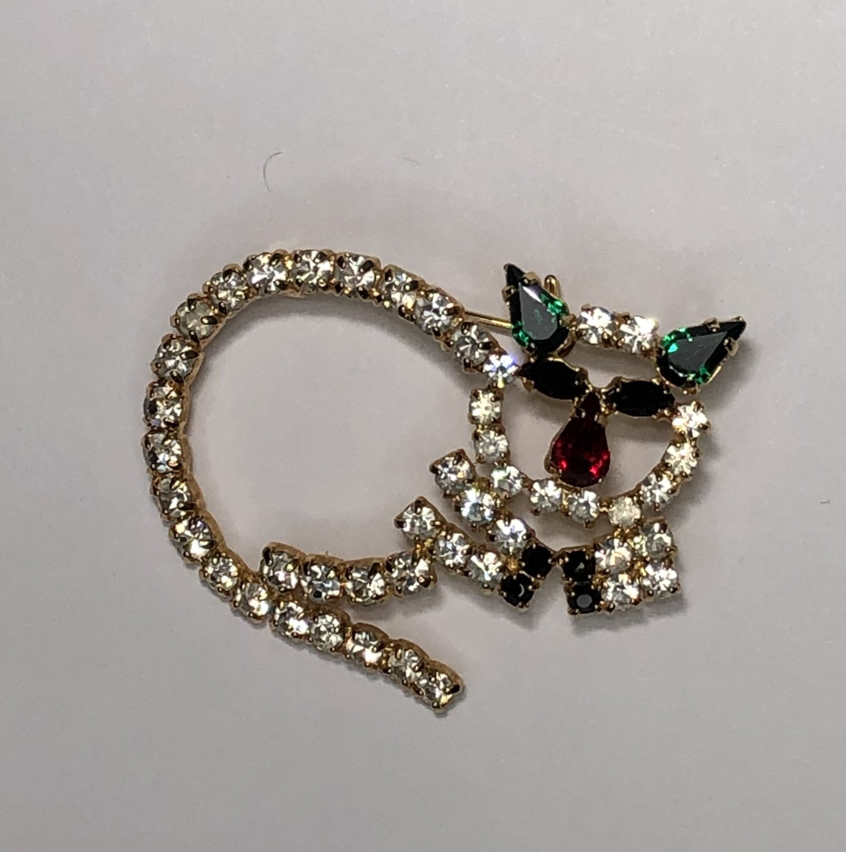 Round diamante cat with emerald ears brooch at erika