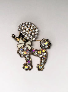 Gold poodle dog with white bow and rainbow diamante brooch at erika