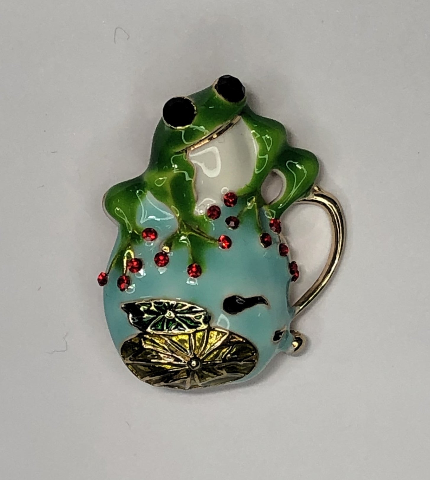 Bejewelled green enameled frog sitting on pond brooch at erika