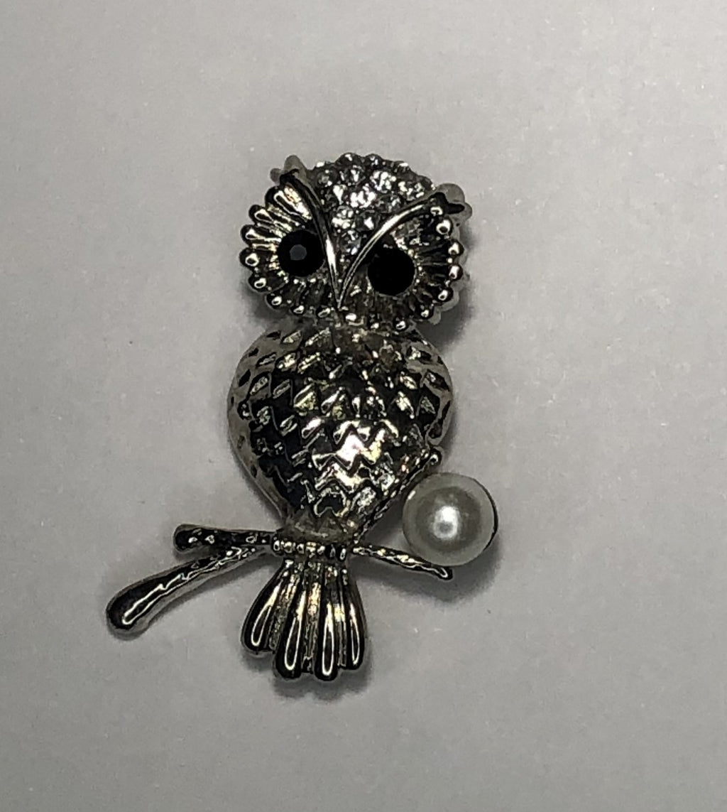 Silver owl perched on a branch with pearl brooch at erika