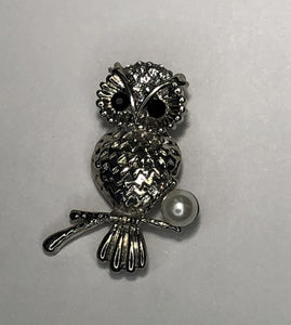 Silver owl perched on a branch with pearl brooch at erika