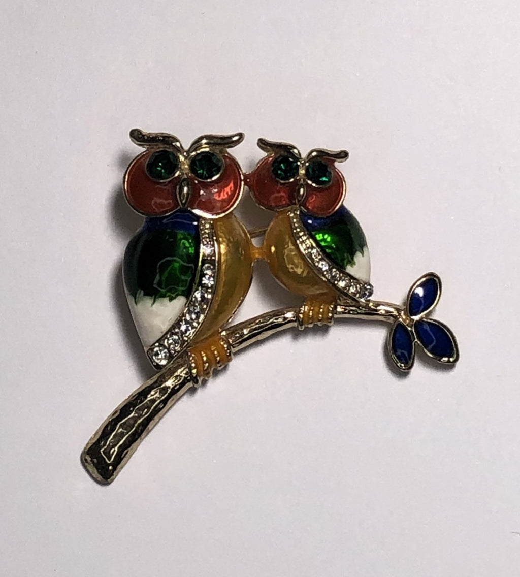 Two colourful enameled owls sitting on branch brooch at erika